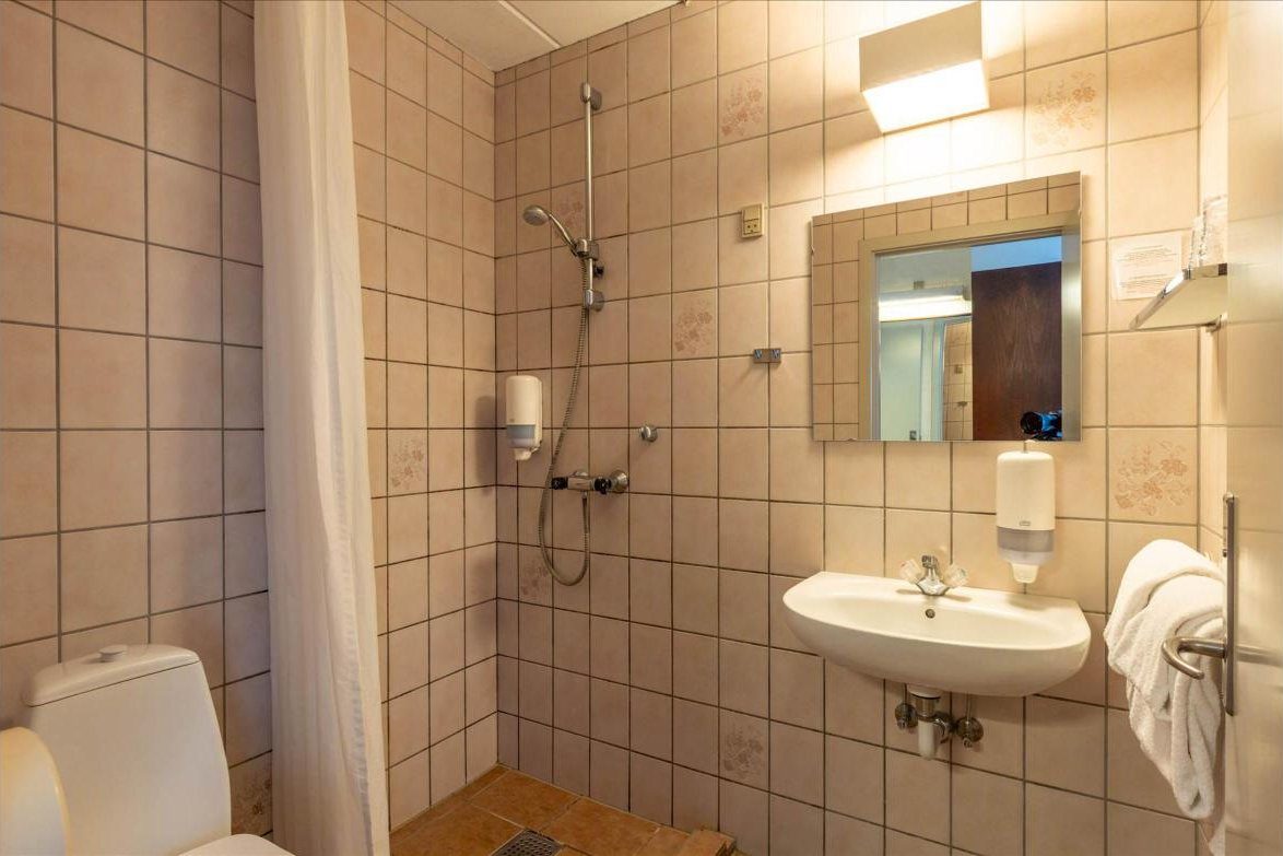 Badeværelse med bruser og håndvask