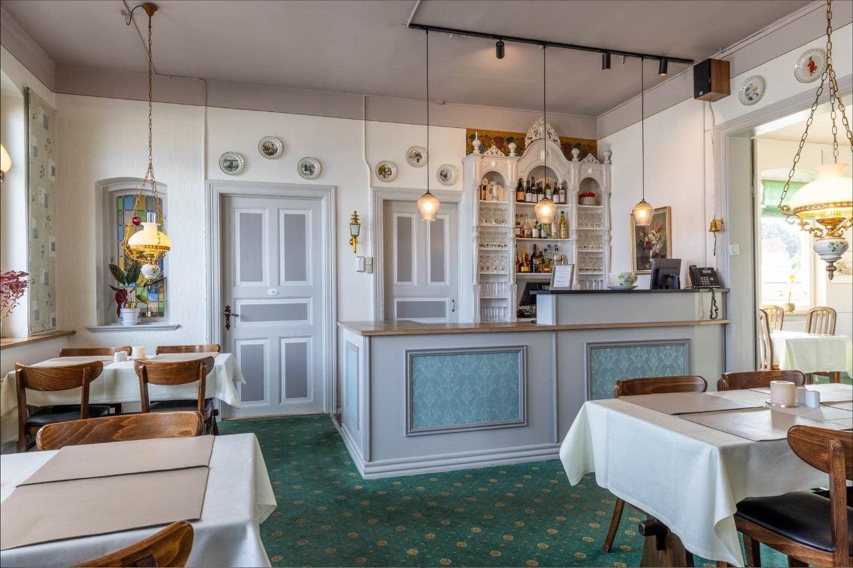 Reception og bar med gamle lamper og blyindfattet vindue