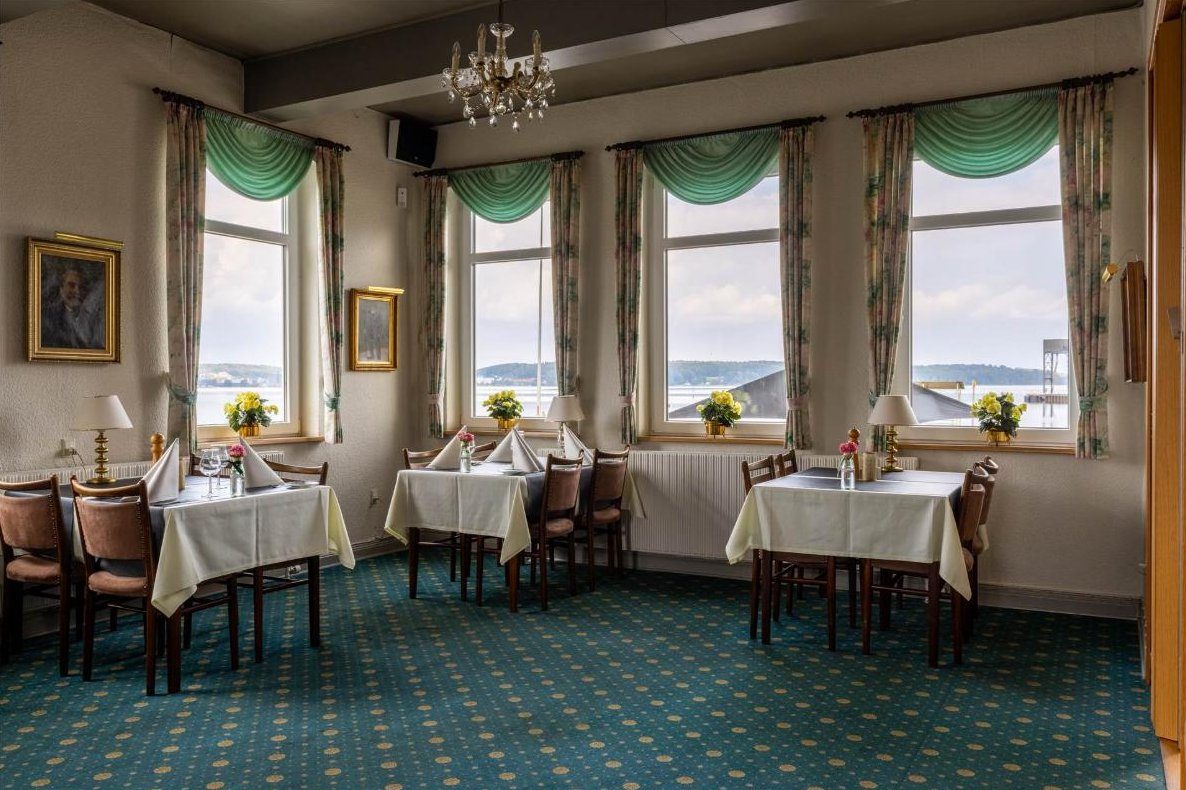 Restauranten med dækkede borde og vinduer ud mod fjorden