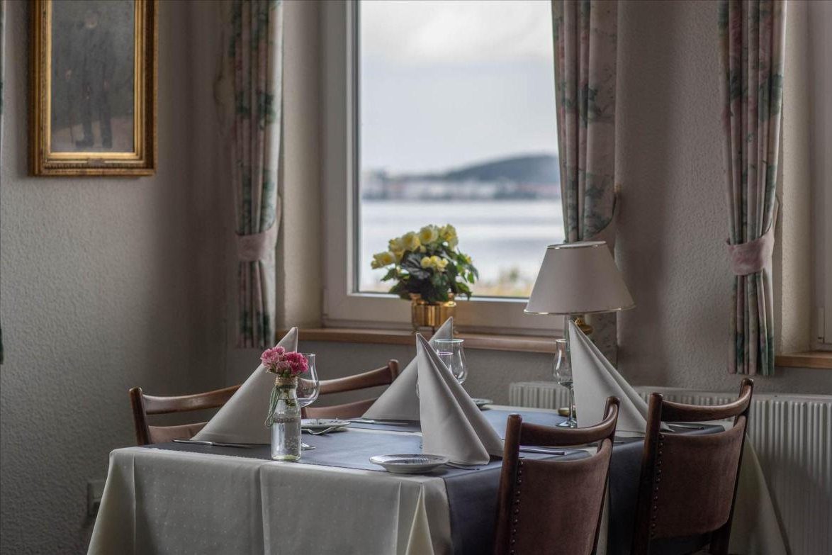 Dækket bord ved vinduet med udsigt over fjorden
